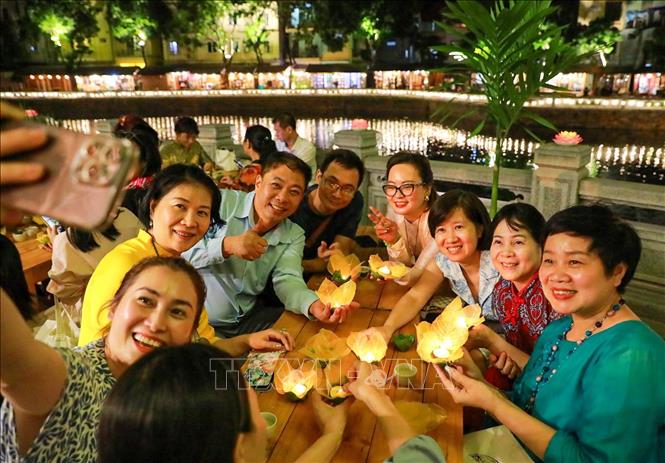 Người dân thích thú trải nghiệm làm đèn hoa đăng. Ảnh: Khánh Hoà - TTXVN