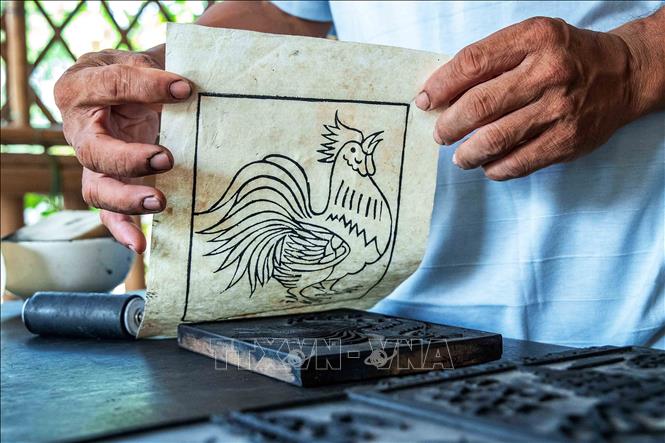 Unlike other types of printed paintings with multiple color blocks, Sinh village paintings only use woodblocks to define the outlines, and then the coloring process is done manually, creating a unique piece for each painting. VNA Photo: Vân Chi/Photo by courtesy