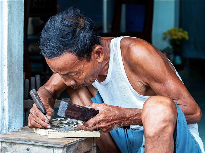 Artisan Ky Huu Phuoc (77 years old) is the 9th generation descendant of the Sinh village painting family. There was a time when this art form was considered superstitious; he secretly buried all the woodblocks to preserve them, thus helping to revive the art form from the brink of extinction. VNA Photo: Vân Chi/Photo by courtesy
