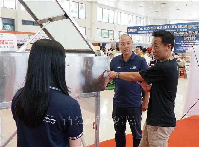 Du khách tham quan, nghe giới thiệu sản phẩm cửa giếng trời thông minh. Ảnh: Quốc Dũng - TTXVN