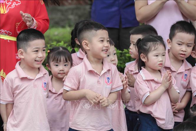 Các em nhỏ hào hứng xem tái hiện cảnh thanh niên họ Hoàng chiến đấu với Giảo Long cứu công chúa. Đây là nghi lễ đặc sắc trong Lễ hội làng Lệ Mật, một Di sản văn hóa phi vật thể quốc gia. Ảnh: Phan Phương – TTXVN 