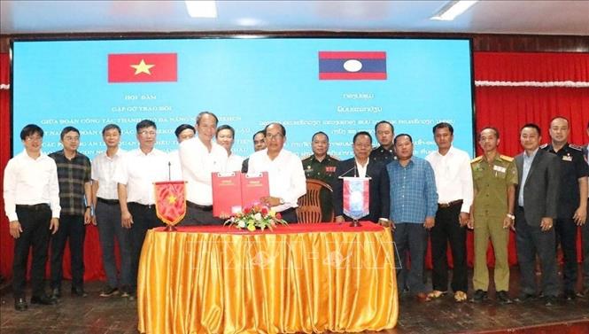 Phó Trưởng ban Quản lý Khu kinh tế mở Chu Lai Thiều Việt Dũng và Giám đốc Sở Tài chính tỉnh Xekong Khamhou Onmani trao đổi Biên bản ký kết. Ảnh: Xuân Tú - PV TTXVN tại Lào