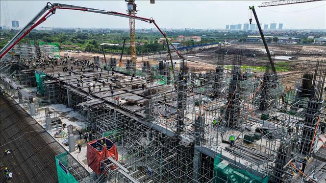 Tính tới thời điểm hiện tại, công trình đang triển khai thi công phần thân và bậc khán đài tầng 1, kết cấu thân đã vươn lên tầng 3, một số khu vực đạt tới tầng 4. Ảnh: Minh Quyết – TTXVN