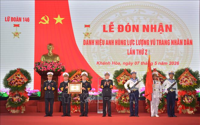 Thừa ủy quyền của Chủ tịch nước, Phó Đô đốc Trần Thanh Nghiêm, Tư lệnh Quân chủng Hải quân gắn danh hiệu, trao bằng và cờ Anh hùng LLVT Nhân dân cho Lữ đoàn 146. Ảnh: Phan Sáu - TTXVN