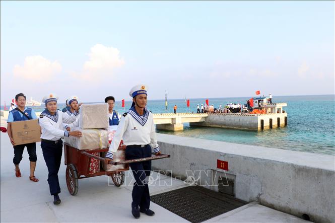 Các chiến sĩ trên đảo Đá Lớn B và đại biểu Thành phố Hồ Chí Minh vận chuyển hàng hóa, đồ dùng lên đảo. Ảnh: Tiến Lực - TTXVN