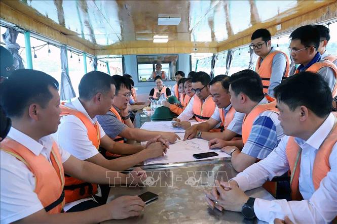 Đoàn khảo sát các vị trí dự kiến triển khai Dự án tại lòng hồ thủy điện Sơn La. Ảnh: Quang Quyết - TTXVN
