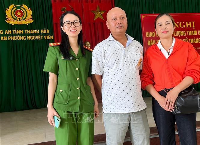 Tại Công an phường Nguyệt Viên, anh Đỗ Trung Cương (giữa) trao trả tiền chuyển nhầm cho chị Đặng Thị Kim Liên (bên phải) trú tại xã Phú Xuyên, thành phố Hà Nội. Ảnh: TTXVN phát 