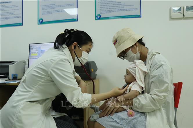 Bác sĩ thăm khám cho bệnh nhân trước khi tiêm phòng. Ảnh: Nguyên Dung – TTXVN