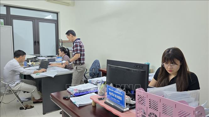 Cán bộ phường Móng Cái 2 làm việc xuyên đêm, đẩy nhanh tiến độ đồng bộ dữ liệu đất đai.  Ảnh: Thanh Vân-TTXVN 