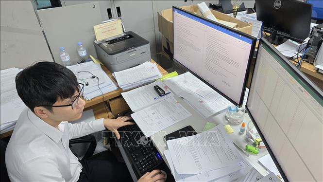 Công chức phường Móng Cái 3 thực hiện song song nhiệm vụ giải quyết TTHC trên cổng dịch vụ công và rà soát dữ liệu đất đai.  Ảnh: Thanh Vân-TTXVN 