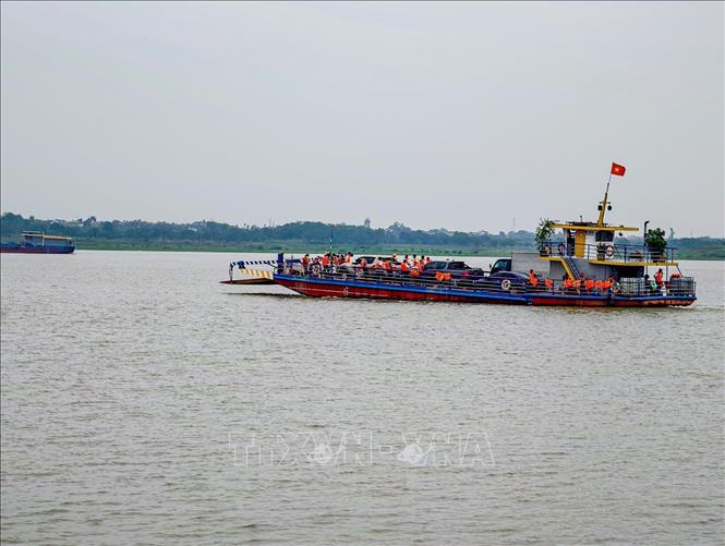 Hành khách mặc áo phao đầy đủ khi di chuyển trên phà qua sông Hồng tại khu vực bến khách ngang sông thuộc địa bàn thành phố Hà Nội. Ảnh: Trung Nguyên - TTXVN