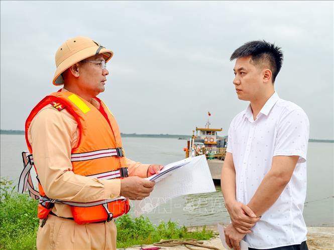Đội Cảnh sát đường thủy số 1 kiểm tra điều kiện an toàn tại bến đò Thọ An (xã Liên Minh, Hà Nội), yêu cầu chủ bến khách ngang sông ký cam kết chấp hành quy định bảo đảm an toàn giao thông đường thủy. Ảnh: Trung Nguyên - TTXVN