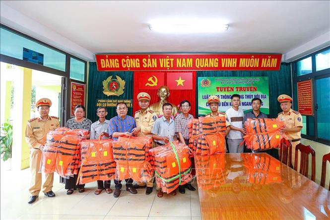 Đội Cảnh sát đường thủy số 1 (Phòng Cảnh sát giao thông Hà Nội) hỗ trợ cấp phát 250 áo phao cho các bến khách ngang sông trên địa bàn quản lý. Ảnh: Trung Nguyên - TTXVN