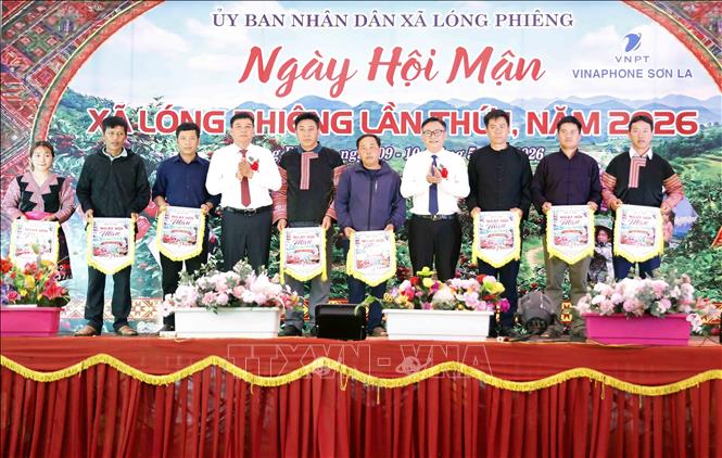 Lãnh đạo xã Lóng Phiêng trao cờ lưu niệm cho đại diện các bản tham gia Ngày hội. Ảnh: Quang Quyết - TTXVN