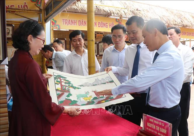 Meritorious Artisan Nguyen Thi Oanh introduces the unique features of Dong Ho folk painting to visitors. Photo: Thanh Thuong – VNA