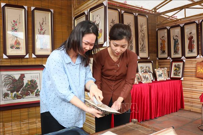 Guiding visitors in printing Dong Ho folk painting. Photo: Thanh Thuong – VNA