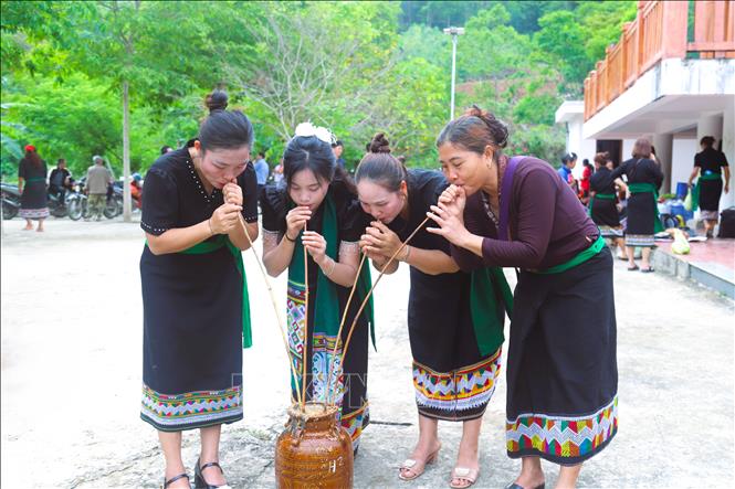 Phụ nữ dân tộc Ơ Đu uống rượu cần trong ngày tổ chức Lễ đón tiếng sấm đầu năm. Ảnh: Xuân Tiến - TTXVN 
