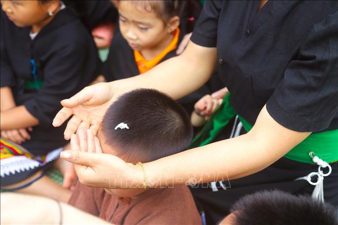  Trong lễ đón tiếng sấm đầu năm cũng diễn ra lễ đặt tên, lễ nhập họ cho trẻ nhỏ trong bản cũng được tổ chức bên mâm cúng vía - một minh chứng sống động cho sự tiếp nối dòng tộc và sự trường tồn của người Ơ Đu. Ảnh: Xuân Tiến - TTXVN 
