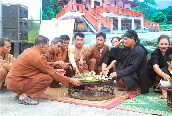Khi mọi người cột chỉ cổ tay, thầy cúng sẽ trực tiếp khấn nguyện để cầu mong các vị thần chứng giám và ban phát những điều may mắn, sức khỏe đến người được buộc chỉ cổ tay. Ảnh: Xuân Tiến - TTXVN 