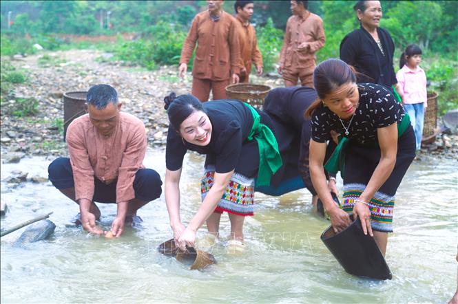 Người dân Ơ Đu bản Văng Môn mang các vật dụng như nồi niêu, mâm, chõ hông xôi, gùi ra suối thiêng Nậm Ngân rửa sạch. Ảnh: Xuân Tiến - TTXVN 