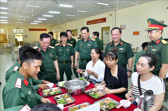 Lãnh đạo Quân khu 7, Bộ Tư lệnh Thành phố Hồ Chí Minh cùng đại diện các gia đình chiến sỹ mới thử bữa ăn chiến sỹ mới trong thời gian huấn luyện. Ảnh: Xuân Khu-TTXVN
