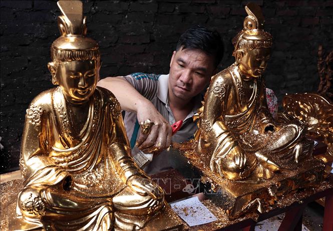 A Buddha statue is gilded through the skillful hands of artisans from Son Dong. Photo: Tran Viet – VNA