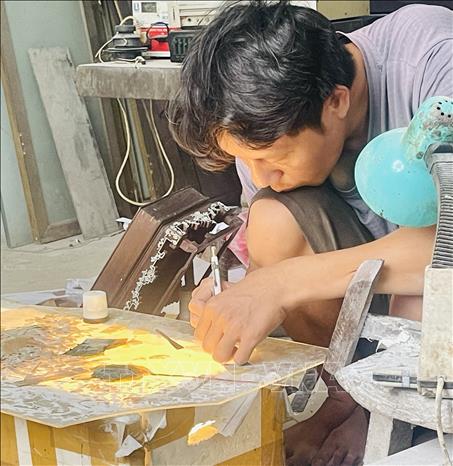 Artisans work tirelessly day and night to create mother-of-pearl inlaid lacquerware products in Chuyen My. Photo: Tuyet Mai – VNA
