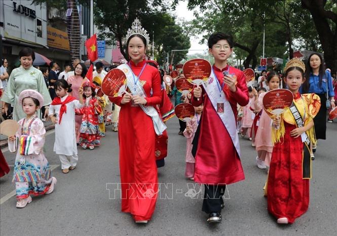 Các em nhỏ tham gia diễu hành trong trang phục truyền thống. Ảnh: Mạnh Minh - TTXVN