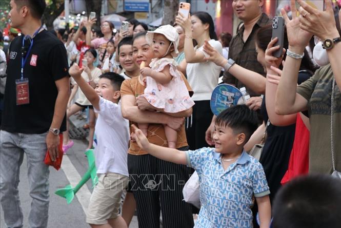 Các em nhỏ hào hứng theo dõi diễu hành. Ảnh: Mạnh Minh - TTXVN