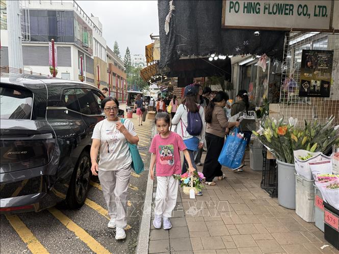 Các bạn nhỏ theo bố mẹ đi mua hoa ở Mong Kok. Ảnh: Mạc Luyện - PV TTXVN tại Hong Kong
