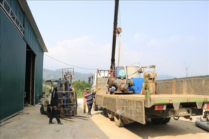 Công nhân tháo dỡ máy móc, trang thiết bị di dời ra khỏi khu vực nhà xưởng tại cơ sở tái chế giấy tại thôn Toàn An, xã Đông Cuông (Lào Cai). Ảnh: Anh Thùy - TTXVN