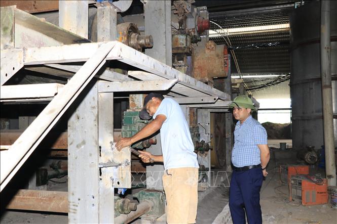 Phó Chủ tịch UBND xã Đông Cuông Trần Thống Nhất kiểm tra quá trình tháo dỡ cơ sở tái chế giấy tại thôn Toàn An, xã Đông Cuông (Lào Cai). Ảnh: Anh Thùy - TTXVN