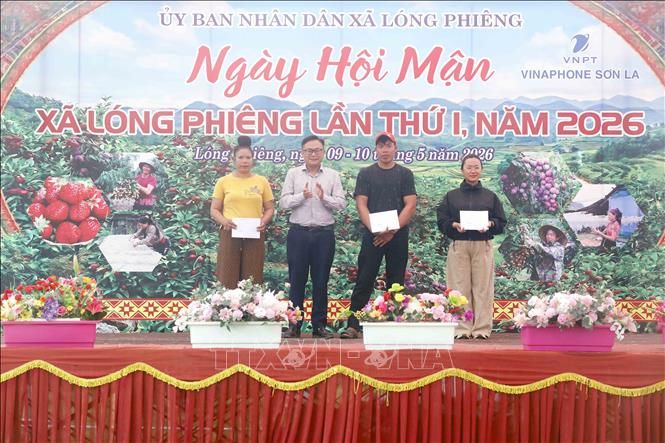 Bí thư Đảng ủy xã Lóng Phiêng Vi Tuấn Bảo trao giải Nhất nội dung đẩy gậy cho cá nhân tại Ngày hội . Ảnh: Quang Quyết - TTXVN