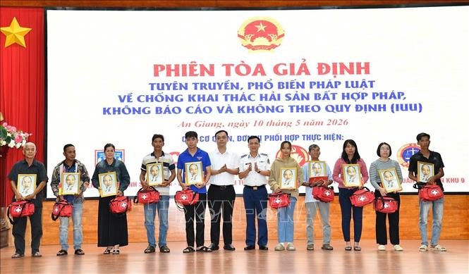 Đại diện Bộ Tư lệnh Vùng Cảnh sát biển 4, Ban Tuyên giáo và Dân vận tỉnh ủy An Giang trao quà tặng các gia đình chính sách, ngư dân hoàn cảnh khó khăn. Ảnh: TTXVN phát