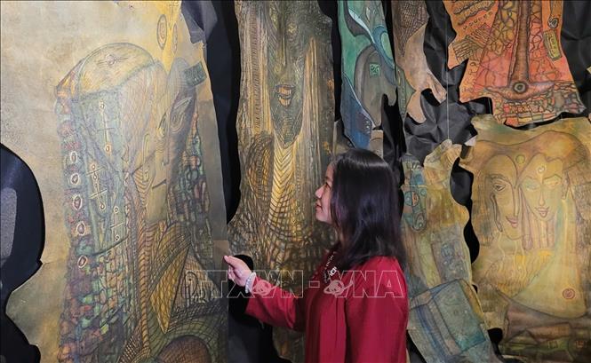 Khách tham quan triển lãm “Hẹn ước mùa sau” của Tiến sĩ, họa sĩ Trịnh Thắng. Ảnh: Phương Thanh-TTXVN