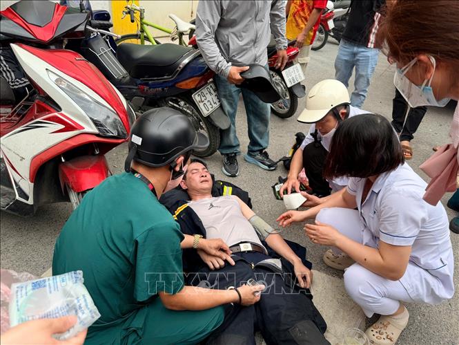 Kịp thời chăm sóc y tế cho một chiến sĩ PCCC kiệt sức khi nỗ lực xử lý đám cháy tại Volume Club (chụp lúc 12h45). Ảnh: Phạm Kiên - TTXVN