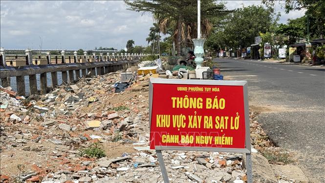 Cơ quan chức năng phường Tuy Hòa gắn biển cảnh báo nguy hiểm tại điểm sạt lở, sụt lún kè Bạch Đằng. Ảnh: Tường Quân – TTXVN 