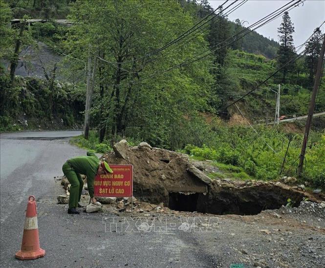 Lực lượng chức năng đặt biển cảnh báo, tiến hành lấp các hố sụt để đảm bảo an toàn. Ảnh: TTXVN phát