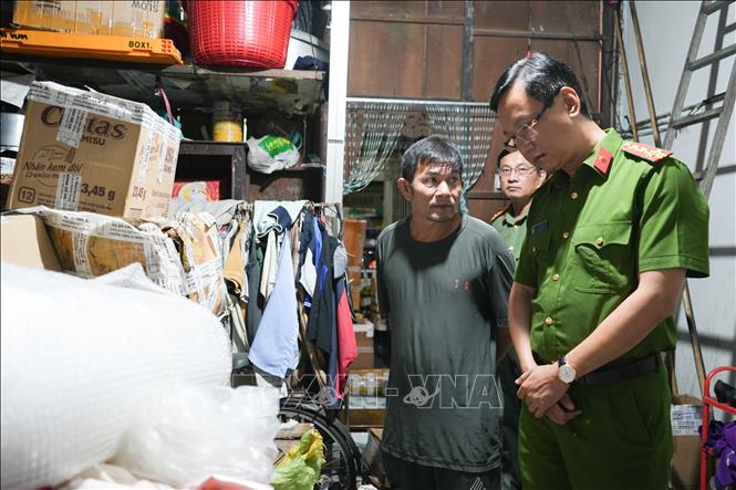 Đại tá Bùi Đức An, Phó Giám đốc Công an thành phố, Thủ trưởng Cơ quan Cảnh sát điều tra trực tiếp có mặt tại hiện trường chỉ đạo khám xét nhà đối tượng Lê Văn Hải (áo đen). Ảnh: TTXVN phát 