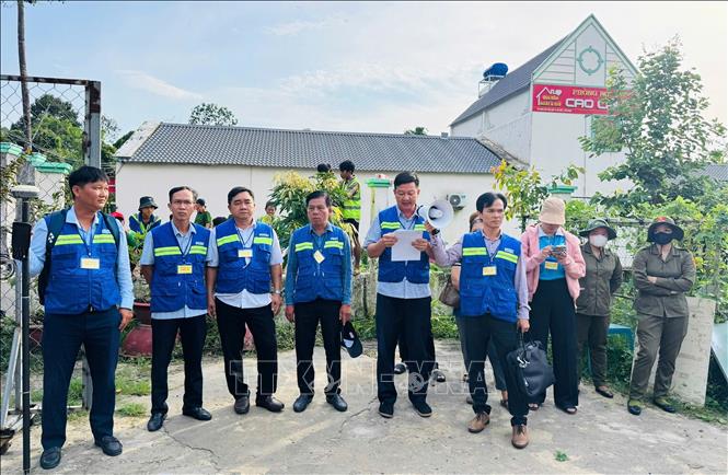 Lực lượng chức năng đọc các quyết định cưỡng chế, thu hồi đất. Ảnh: TTXVN phát