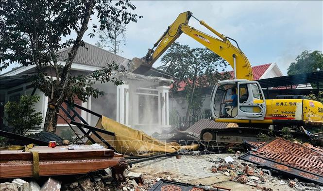 Lực lượng chức năng thực hiện công tác cưỡng chế. Ảnh: TTXVN phát