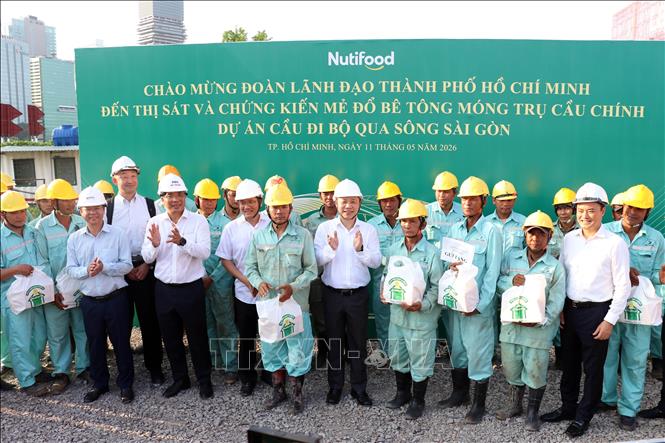 Lãnh đạo TP. Hồ Chí Minh tặng quà cho công nhân tại công trường. Ảnh: Tiến Lực - TTXVN