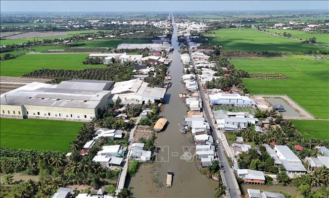 Hoạt động bơm thổi trấu không được che chắn cẩn thận của các nhà máy xay xát lúa gạo ven kênh Thốt Nốt (ấp Thạnh Hưng, xã Cờ Đỏ) phát tán bụi ra môi trường gây ảnh hưởng đến khu dân cư đối diện. Ảnh: Thanh Liêm - TTXVN