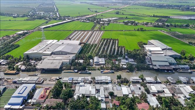 Các nhà máy xay xát lúa gạo ven kênh Thốt Nốt (ấp Thạnh Hưng, xã Cờ Đỏ) phát tán bụi ra môi trường gây ảnh hưởng đến khu dân cư đối diện. Ảnh: Thanh Liêm - TTXVN
