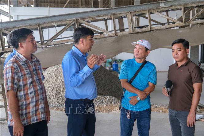 Ông Lê Chí Phương, Chủ tịch UBND xã Cờ Đỏ (thứ hai, bên trái) yêu cầu chủ Nhà máy Thành Tâm Cờ Đỏ nhanh chóng khắc phục tình trạng bụi trấu phát tán ra môi trường. Ảnh: Thanh Liêm - TTXVN