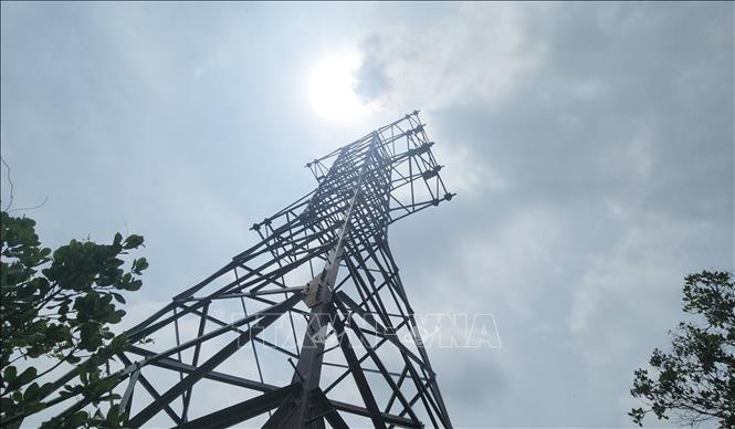 Một trụ điện bị nghiêng hẳn sang một bên, 3 chân bị bung ra ngoài. Ảnh: Đậu Tất Thành – TTXVN