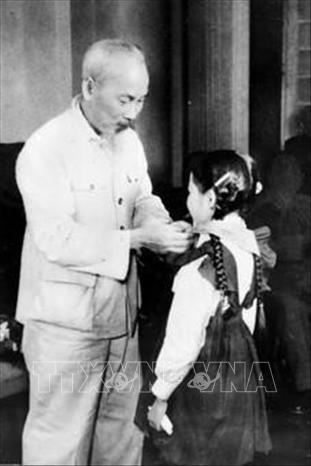 Chủ tịch Hồ Chí Minh quàng khăn đỏ cho đại biểu thiếu nhi Thủ đô đến chúc mừng Kỷ niệm 30 năm Ngày thành lập Đảng (1960). Ảnh: Tư liệu TTXVN