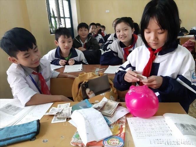 Thông qua các phong trào thi đua, các chương trình hoạt động, Đội đã góp phần hình thành ở thiếu nhi những phẩm chất tốt đẹp như yêu nước, chăm ngoan, học giỏi, đoàn kết, kỷ luật và sáng tạo. Trong ảnh: Học sinh trường Tiểu học Bắc Hồng ở thị xã Hồng Lĩnh (Hà Tĩnh) tiết kiệm mỗi ngày 1.000 đồng đến 2.000 đồng từ tiền tiêu vặt để bỏ vào heo nhựa giúp đỡ các bạn nghèo. Ảnh: TTXVN phát