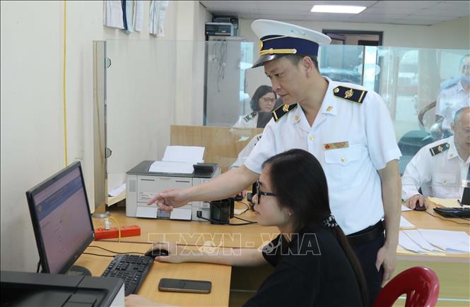 Lực lượng Kiểm dịch y tế cửa khẩu Tân Thanh (Lạng Sơn) hướng dẫn doanh nghiệp khai báo thủ tục xuất nhập khẩu trên không gian mạng. Ảnh: Quang Duy - TTXVN