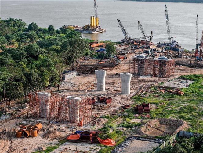 Khu vực dự án phía bên kia sông hiện đã hoàn thành GPMB và được triển khai xây dựng các hạng mục trụ cầu, hệ thống thoát nước... Ảnh: Phạm Tuấn Anh - TTXVN